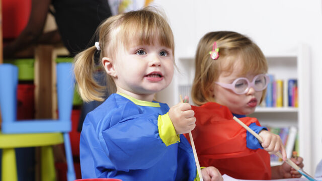 Two toddler paint in a preschool classroom.